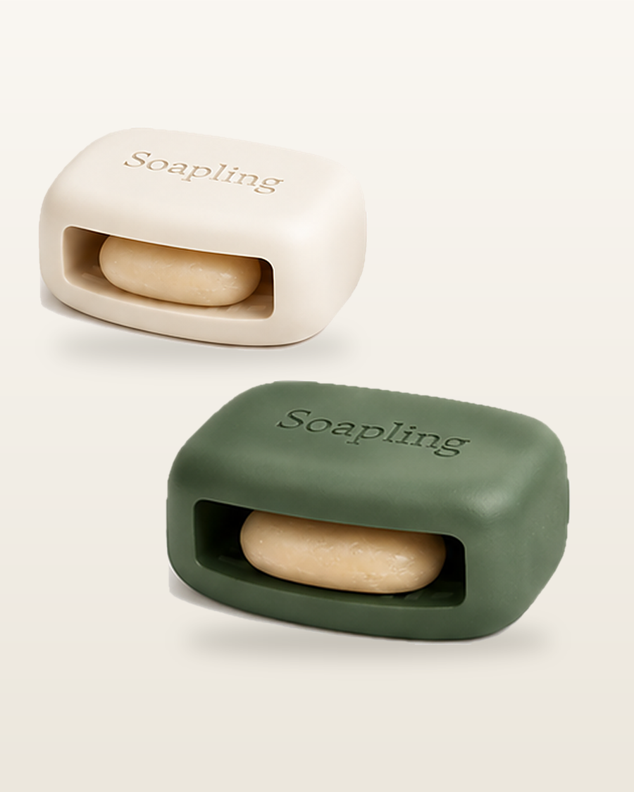 Two Soapling bars in Cream and Sage Deep, each with a soap sliver tucked into its side pocket